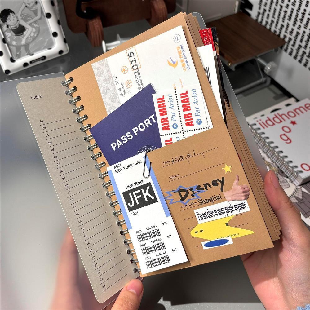 A5 kraft paper travel journal open showing pocket pages with boarding passes passport and stickers
