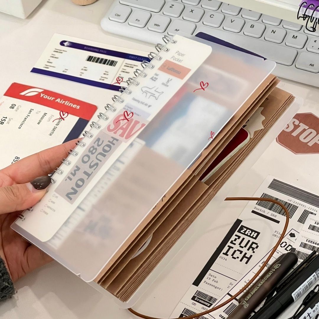 A5 kraft paper travel journal open with flight boarding pass stickers and Polaroid photo close-up