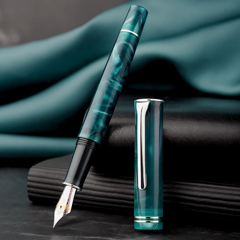 Hongdian teal fountain pen and cap on a dark notebook